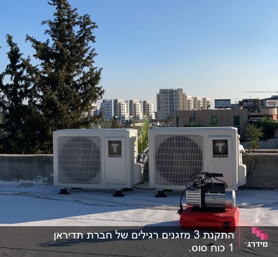 שני מזגנים על גג עם מכשיר על אדום
